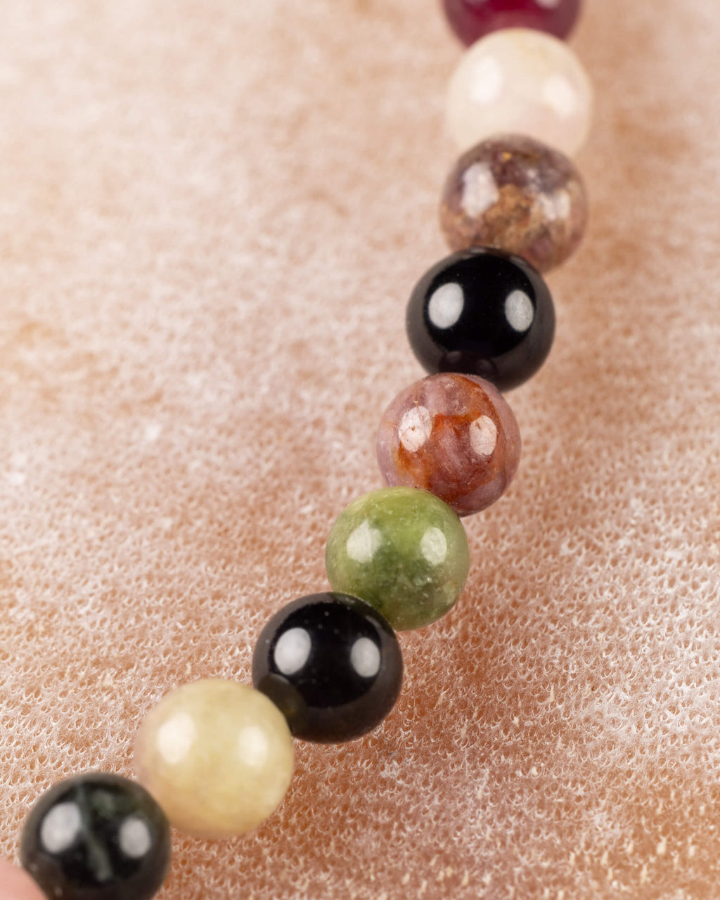 Detalle macro de cuentas de Turmalina en tonos crema, negro, café y verde