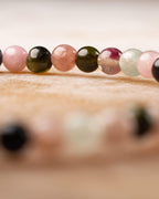 Detalle macro de cuentas de Turmalina rosa, verde oliva y negra en fila