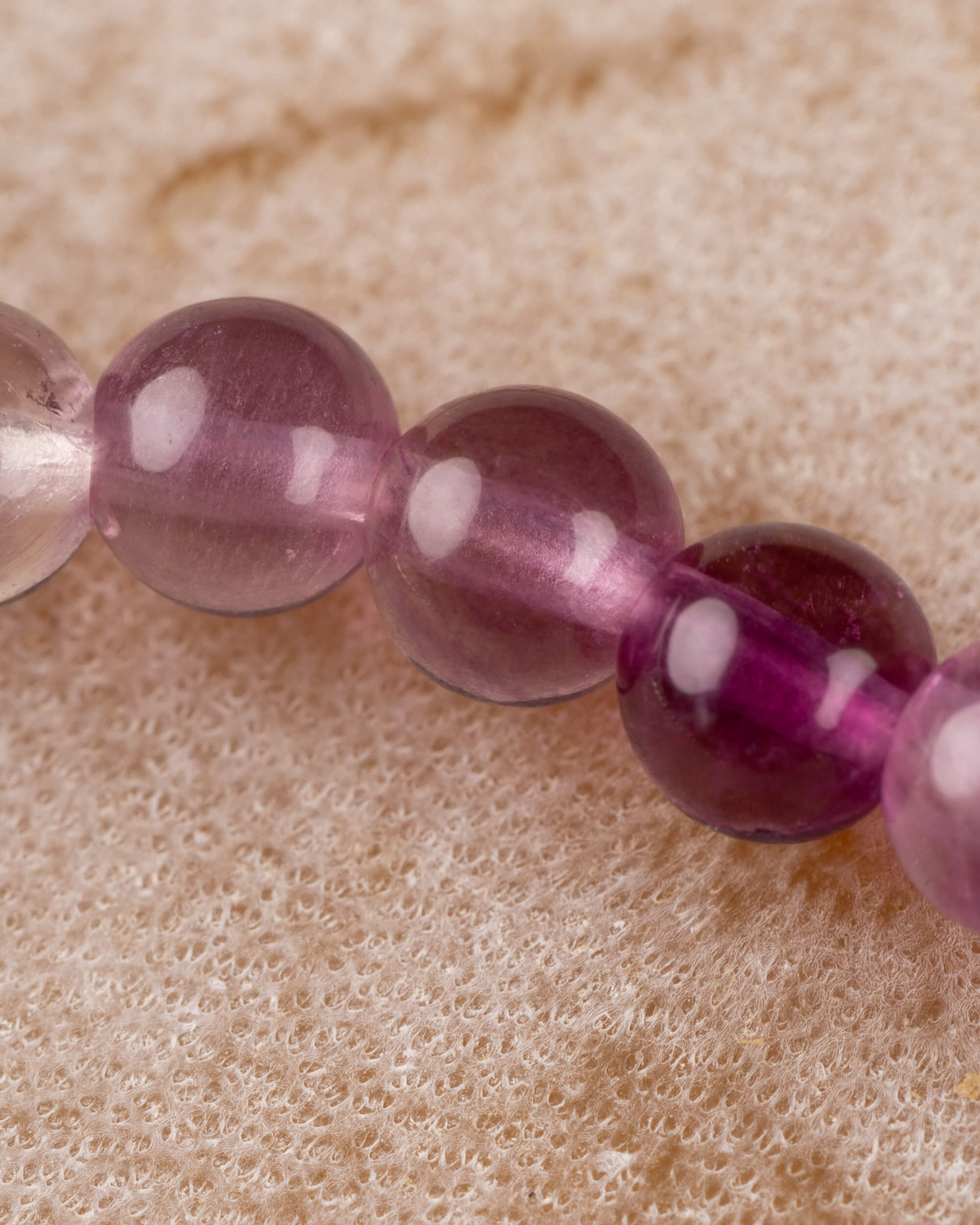 Detalle macro de cuentas moradas y rosadas de la Fluorita Arcoíris