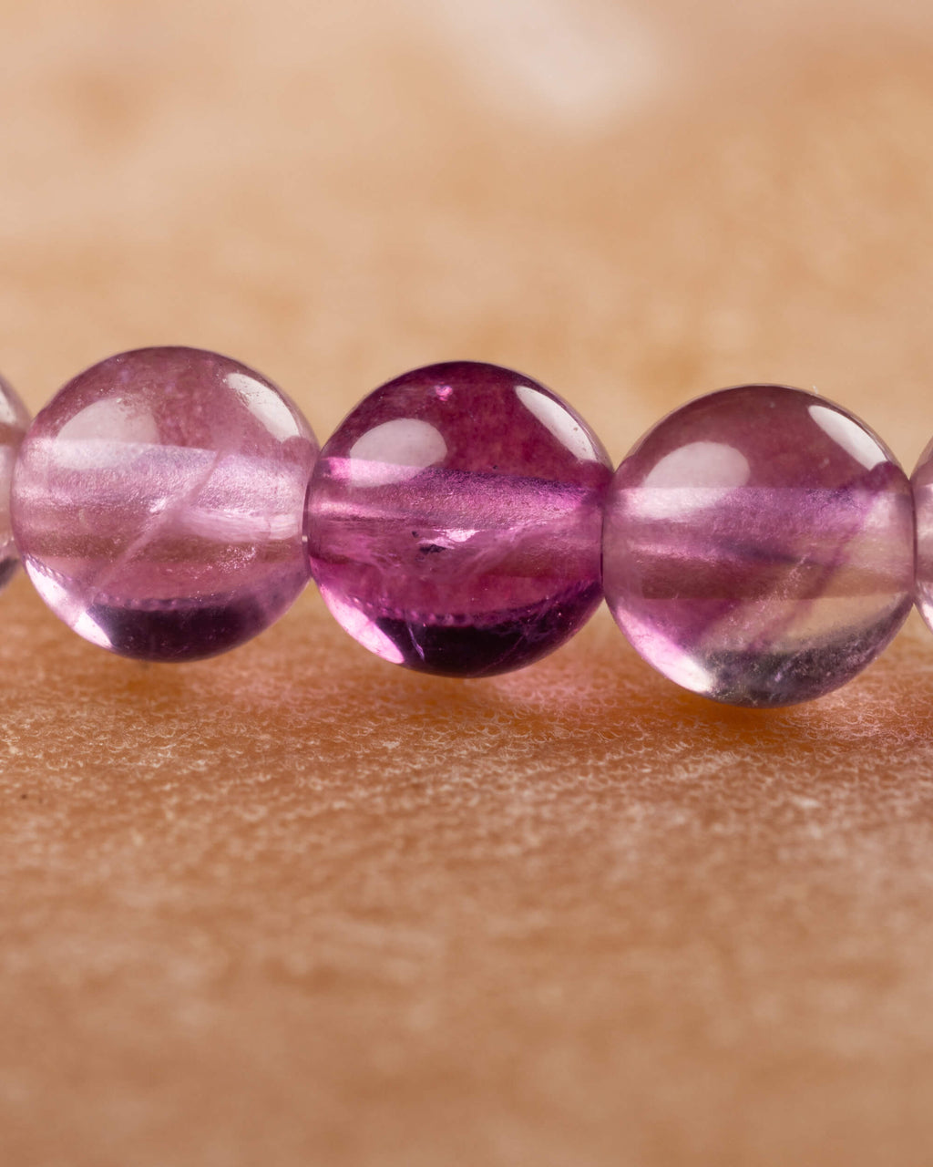 Detalle macro de cuentas moradas y rosadas de la Fluorita Arcoíris