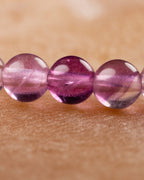 Detalle macro de cuentas moradas y rosadas de la Fluorita Arcoíris