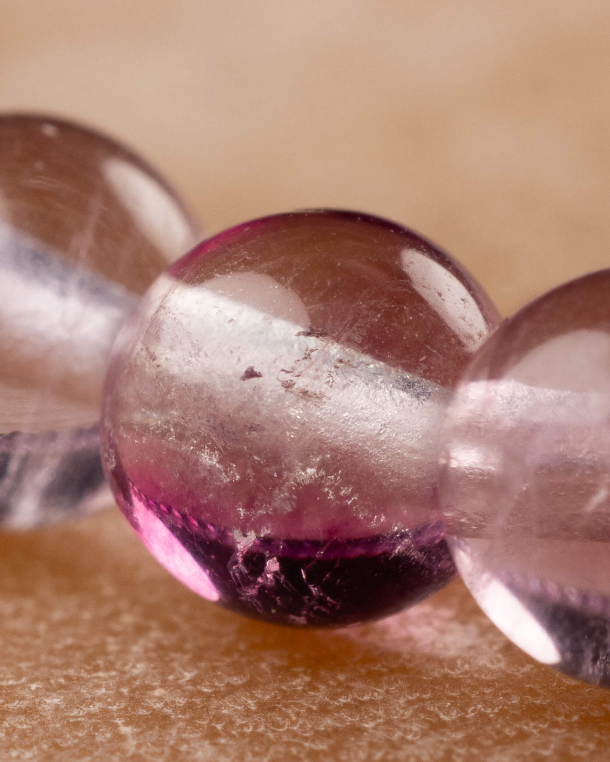 Detalle macro de una cuenta morada y rosa de la Fluorita Arcoíris