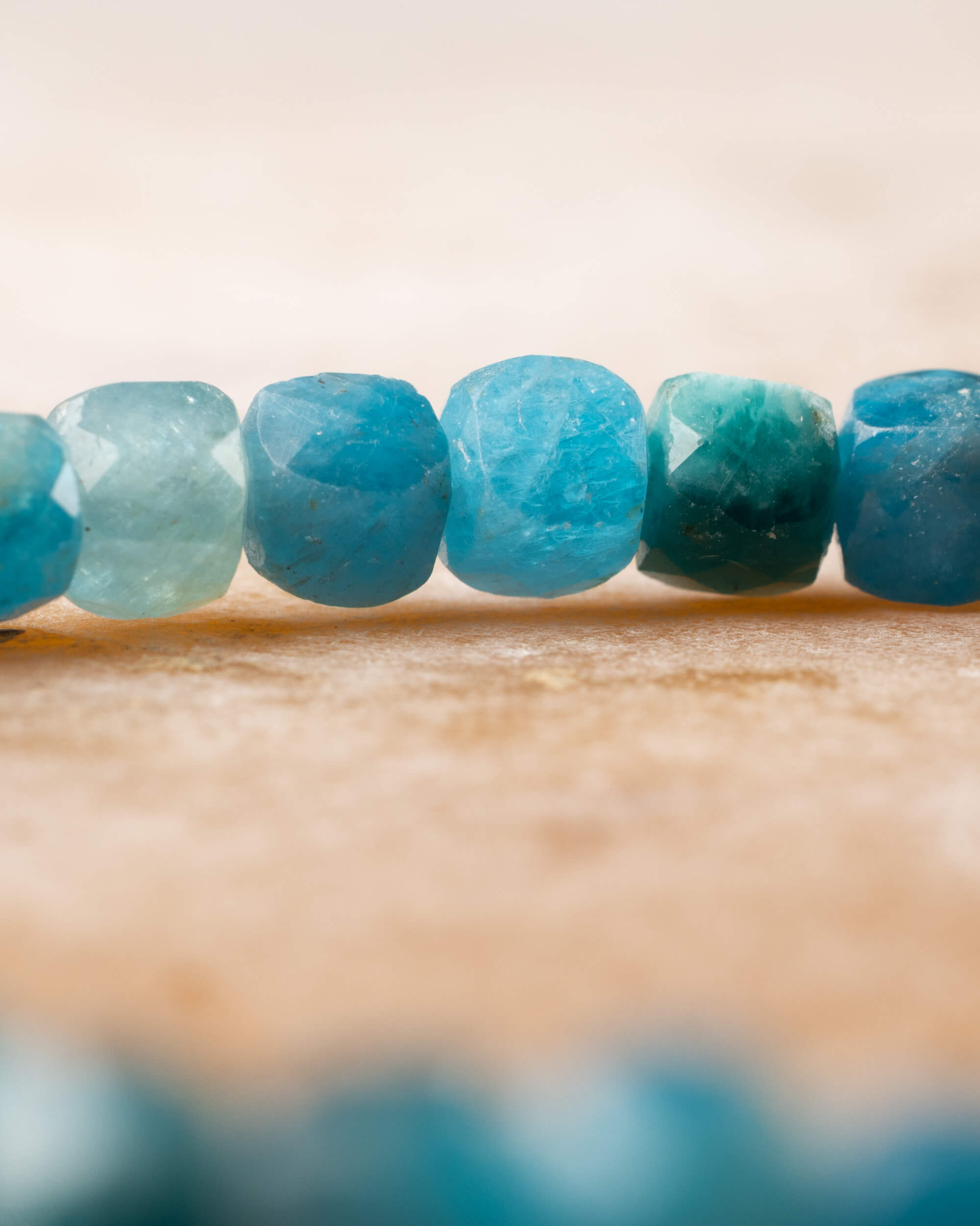 Detalle macro de las cuentas facetadas de Apatita Azul con una cuenta verde