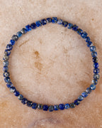 Pulsera de Lapislázuli facetada, pieza completa en círculo sobre superficie clara