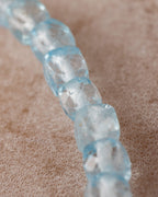 Detalle macro de cuentas facetadas de Topacio Azul en fila vertical descendente
