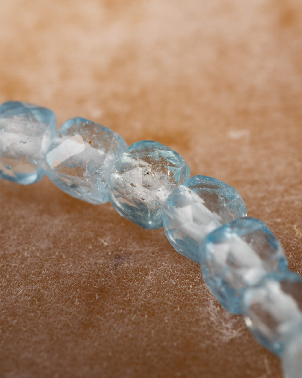 Detalle macro de cuentas de Topacio Azul con destellos de luz en las facetas