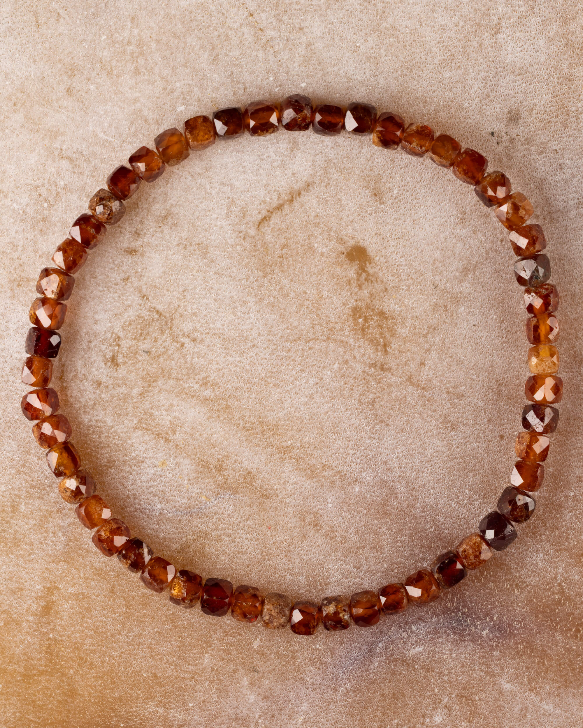 Pulsera de Granate Espesartina facetada de 4 mm, pieza completa circular sobre superficie clara