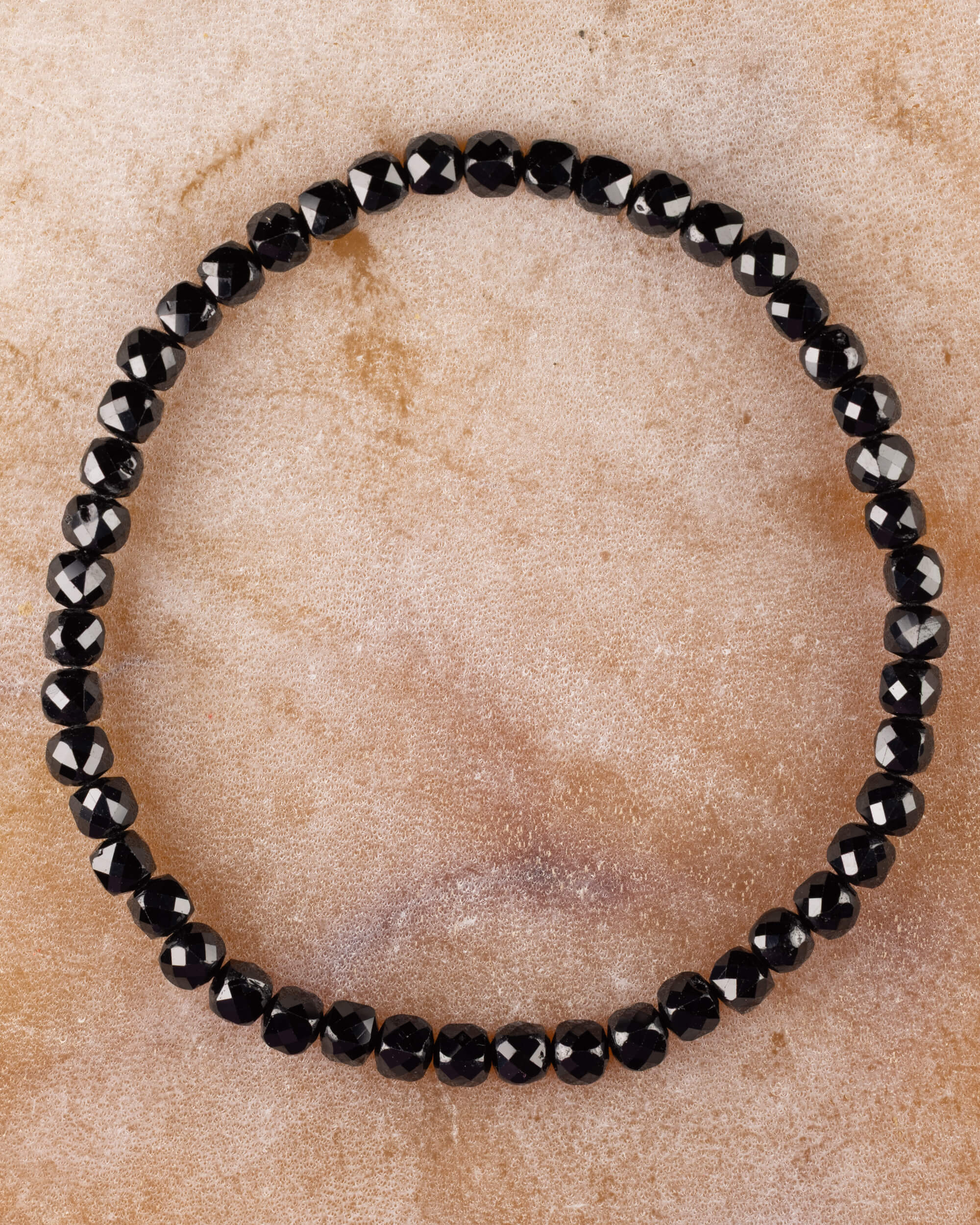 Pulsera de Espinela Negra de 4 mm facetada, pieza completa sobre superficie clara