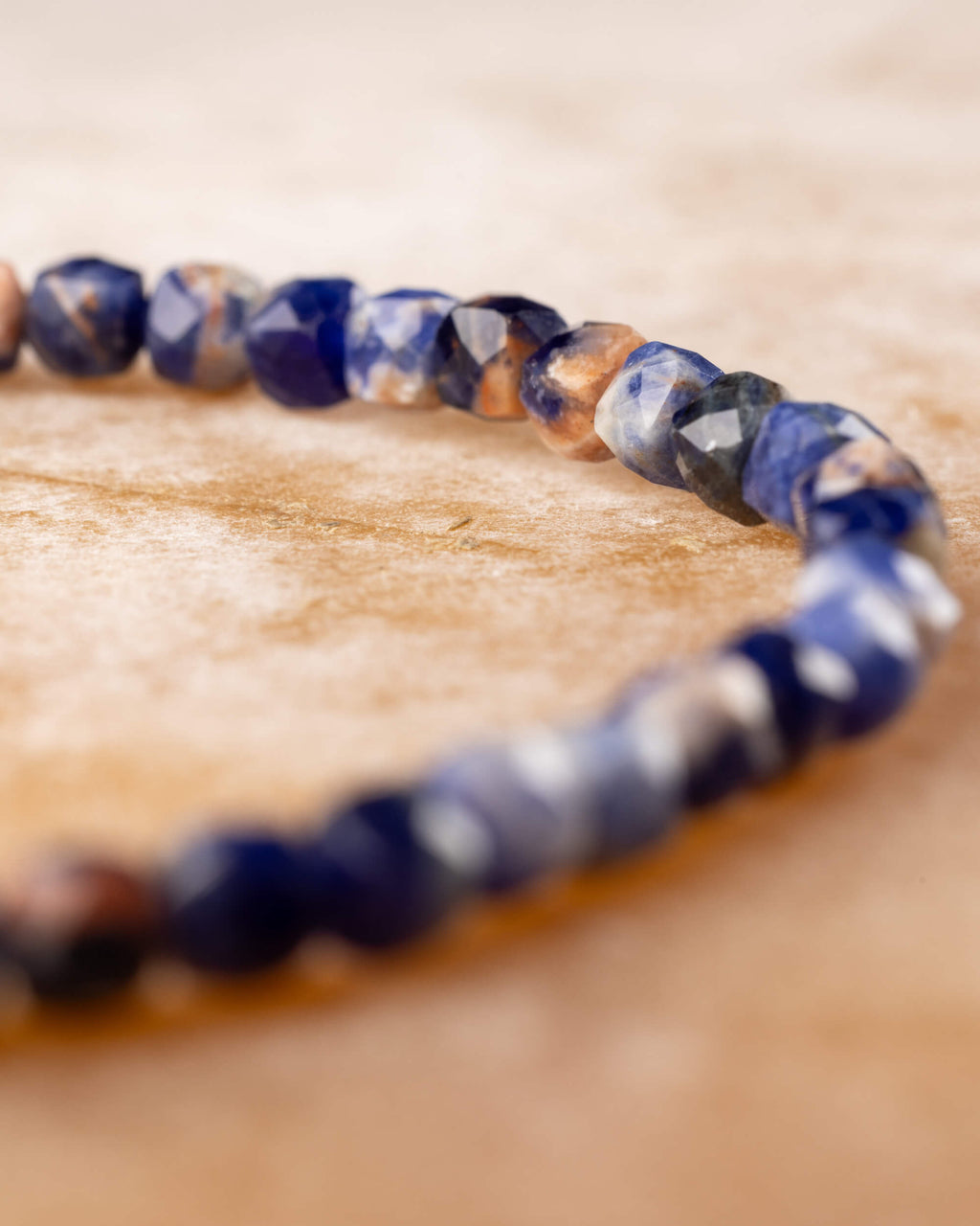 Pulsera de Sodalita en perspectiva, cuentas facetadas azul y blanco al frente