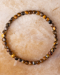 Pulsera de Ojo de Tigre facetada, pieza completa en círculo sobre superficie clara