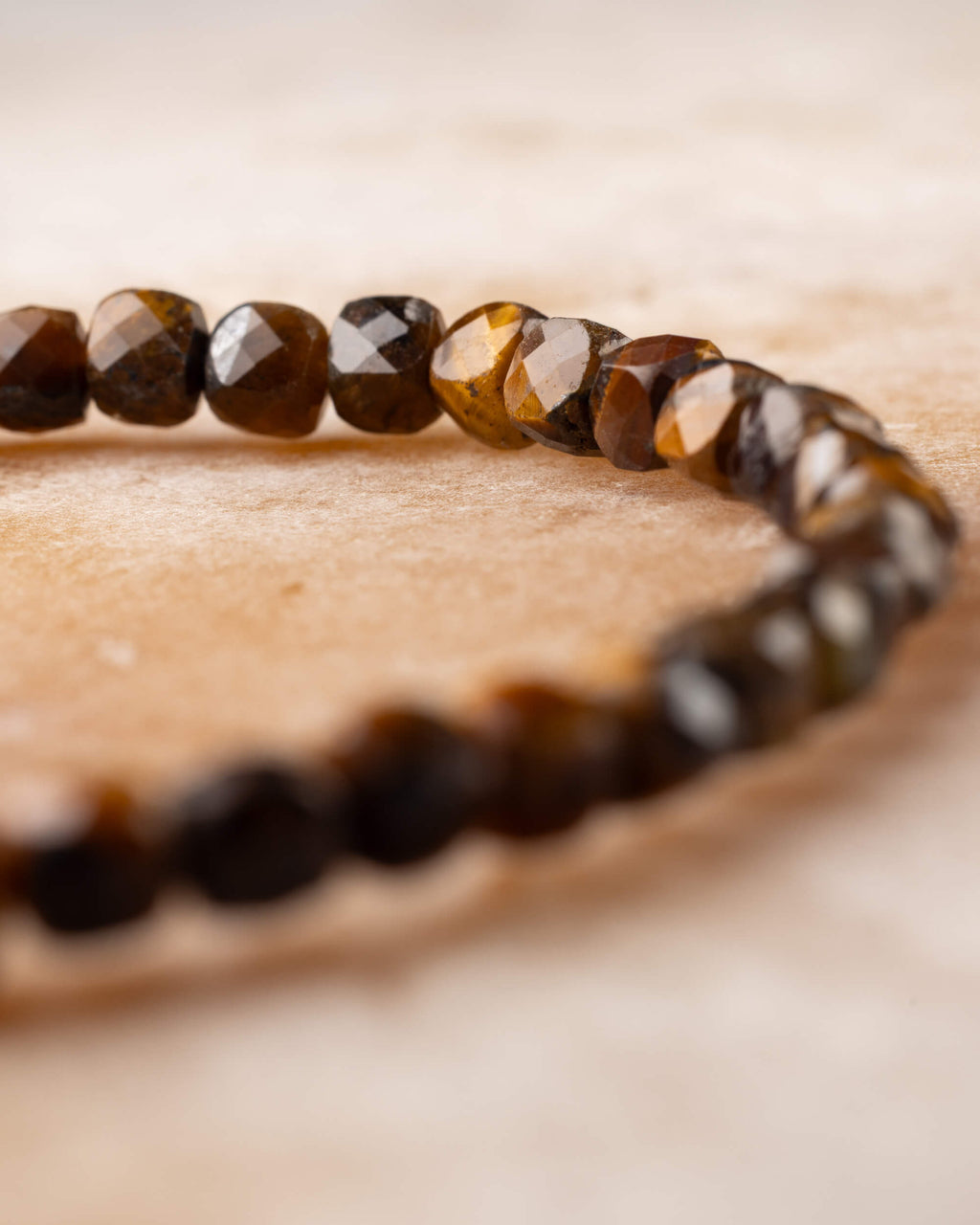 Cuentas de Ojo de Tigre en curva, enfoque en el tramo delantero de la pulsera