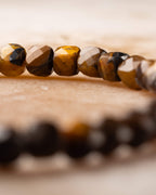 Detalle macro vertical de las cuentas de Ojo de Tigre con brillo dorado