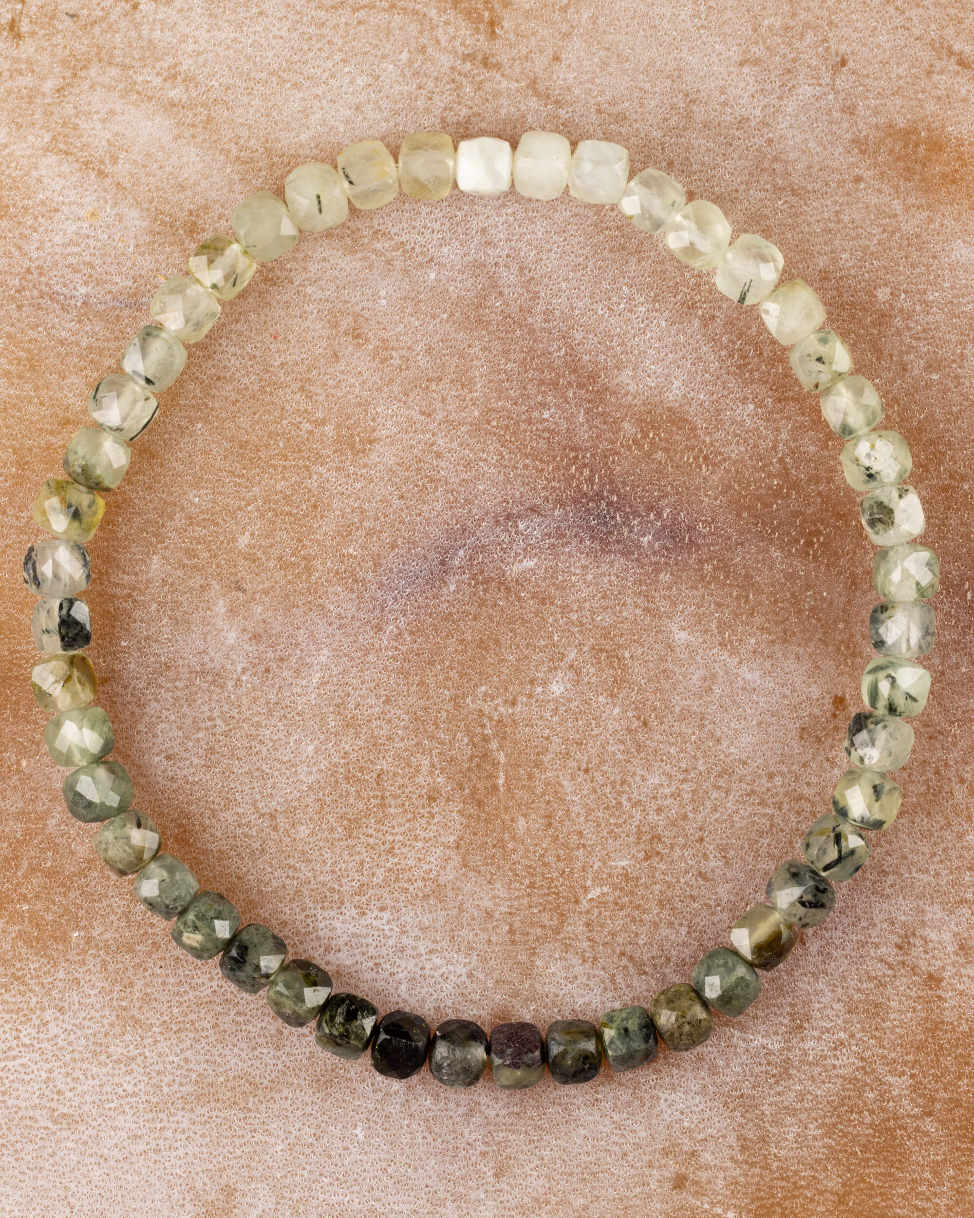 Pulsera de Prehnita de 4 mm facetada, pieza completa en círculo sobre superficie de piedra