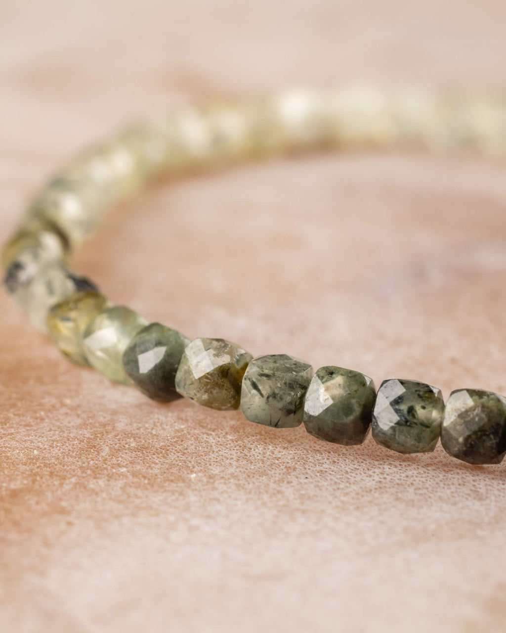 Pulsera de Prehnita en perspectiva, degradado de tonos claros a verde oscuro