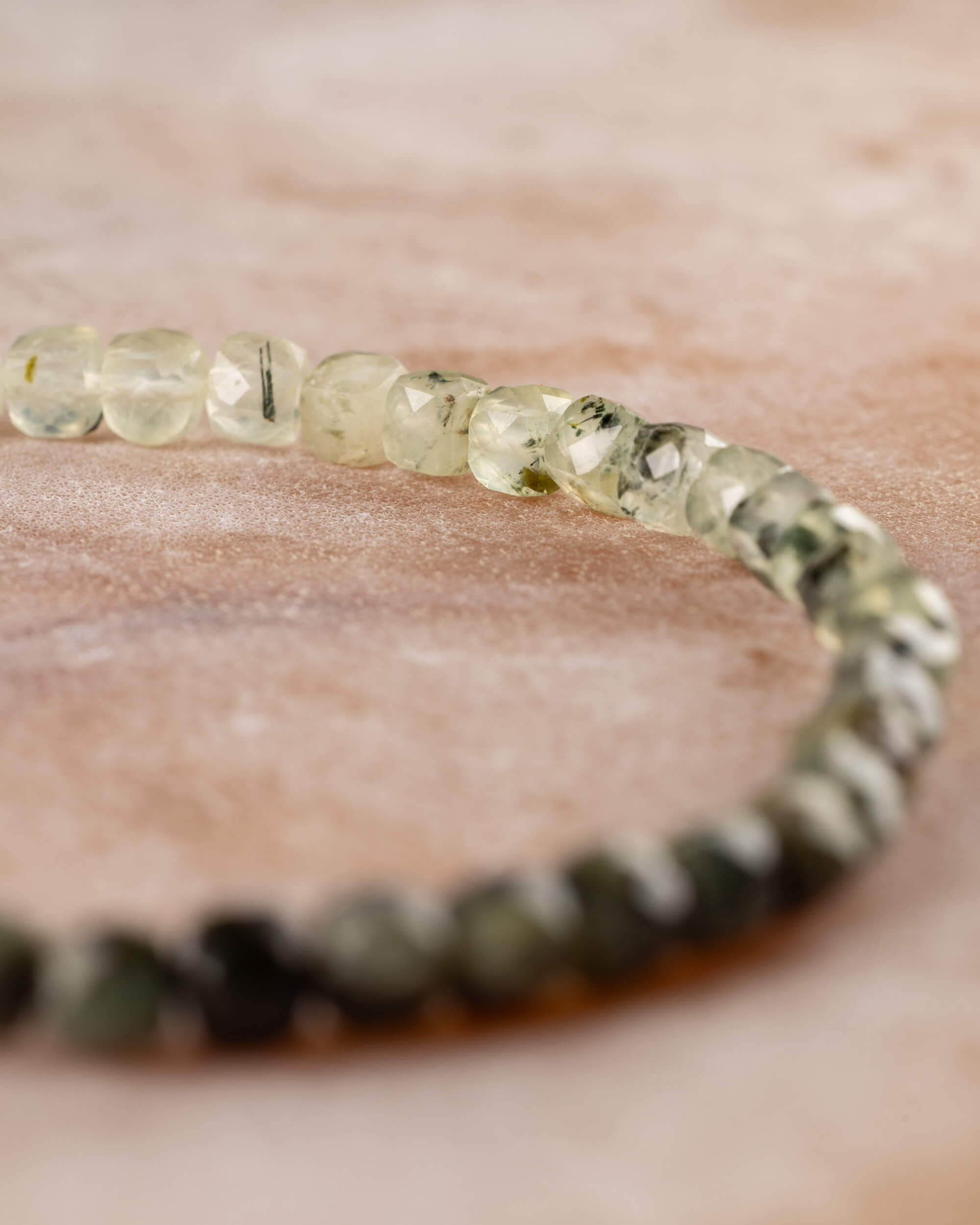 Pulsera de Prehnita en perspectiva, de tonos claros hacia verde oscuro
