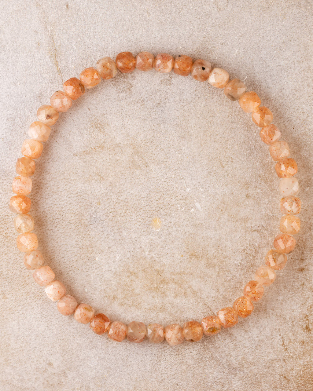Pulsera de Piedra Sol Naranja de 4 mm facetada, pieza completa en círculo sobre piedra clara