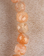 Detalle macro vertical de las cuentas de Piedra Sol Naranja con destellos