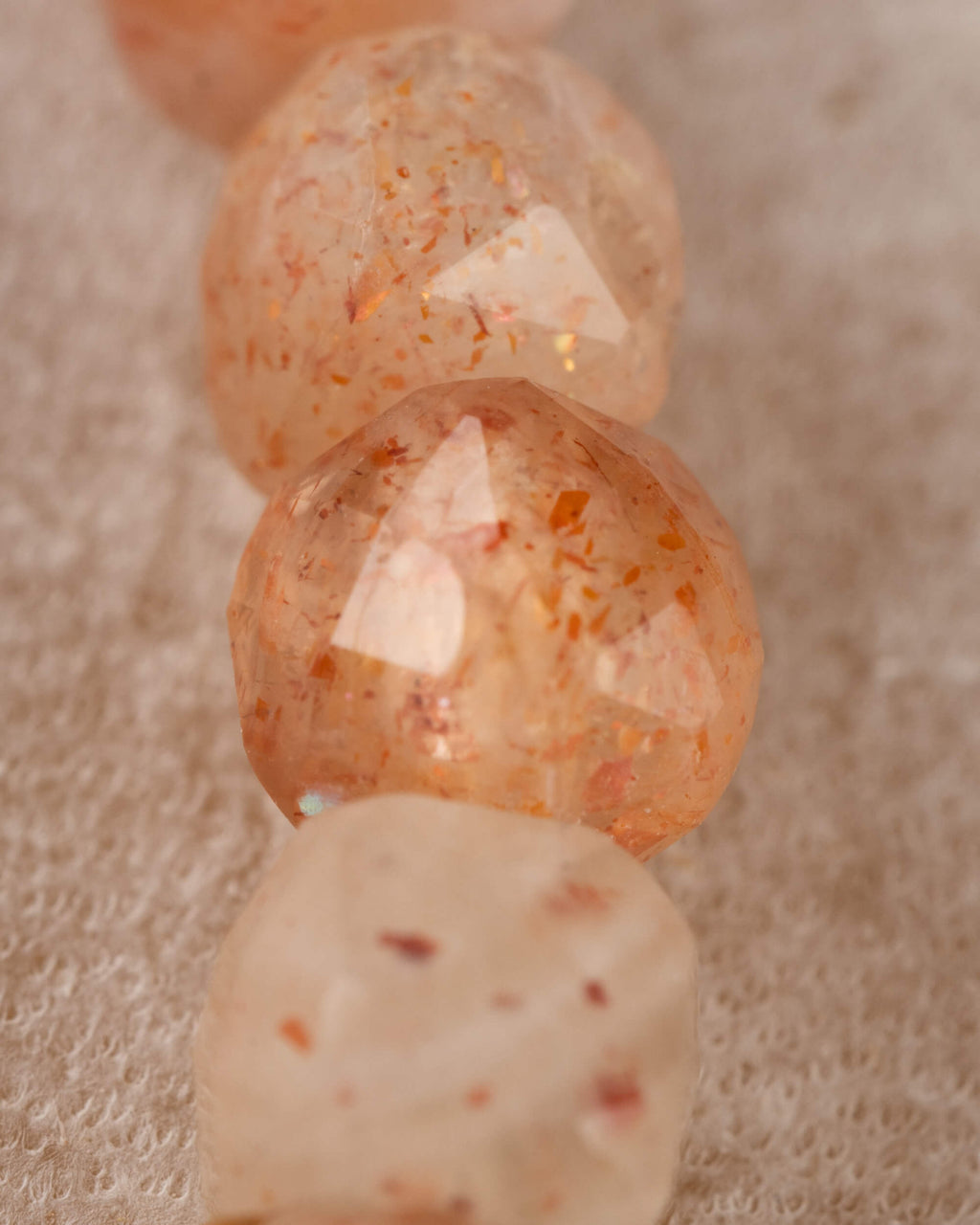 Detalle macro de las cuentas de Piedra Sol Naranja con destellos dorados
