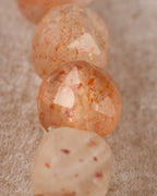 Detalle macro de las cuentas de Piedra Sol Naranja con destellos dorados