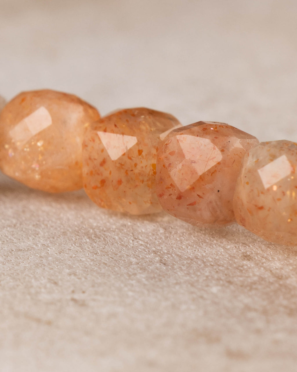Acercamiento a cuatro cuentas facetadas de Piedra Sol Naranja