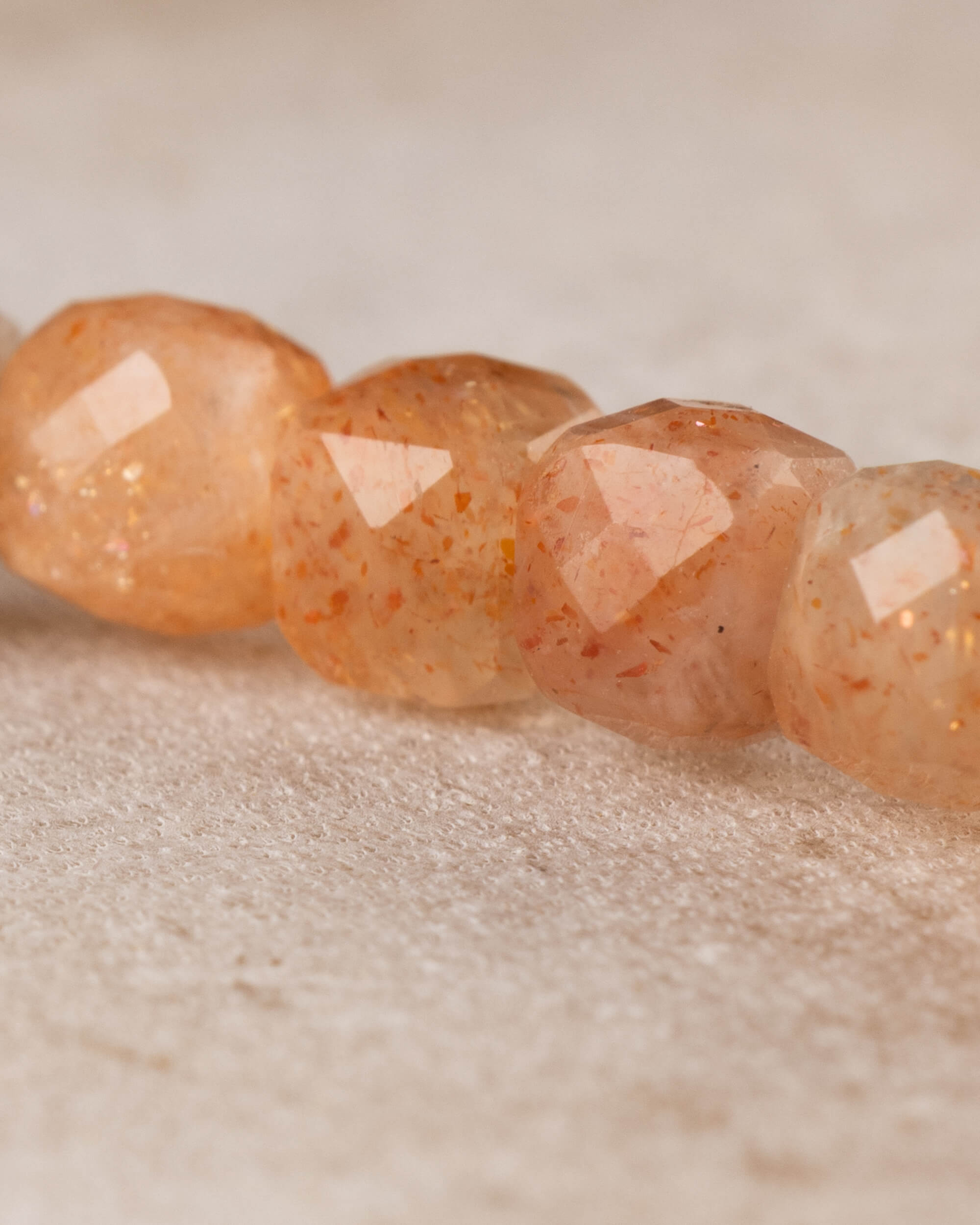 Acercamiento a cuatro cuentas facetadas de Piedra Sol Naranja