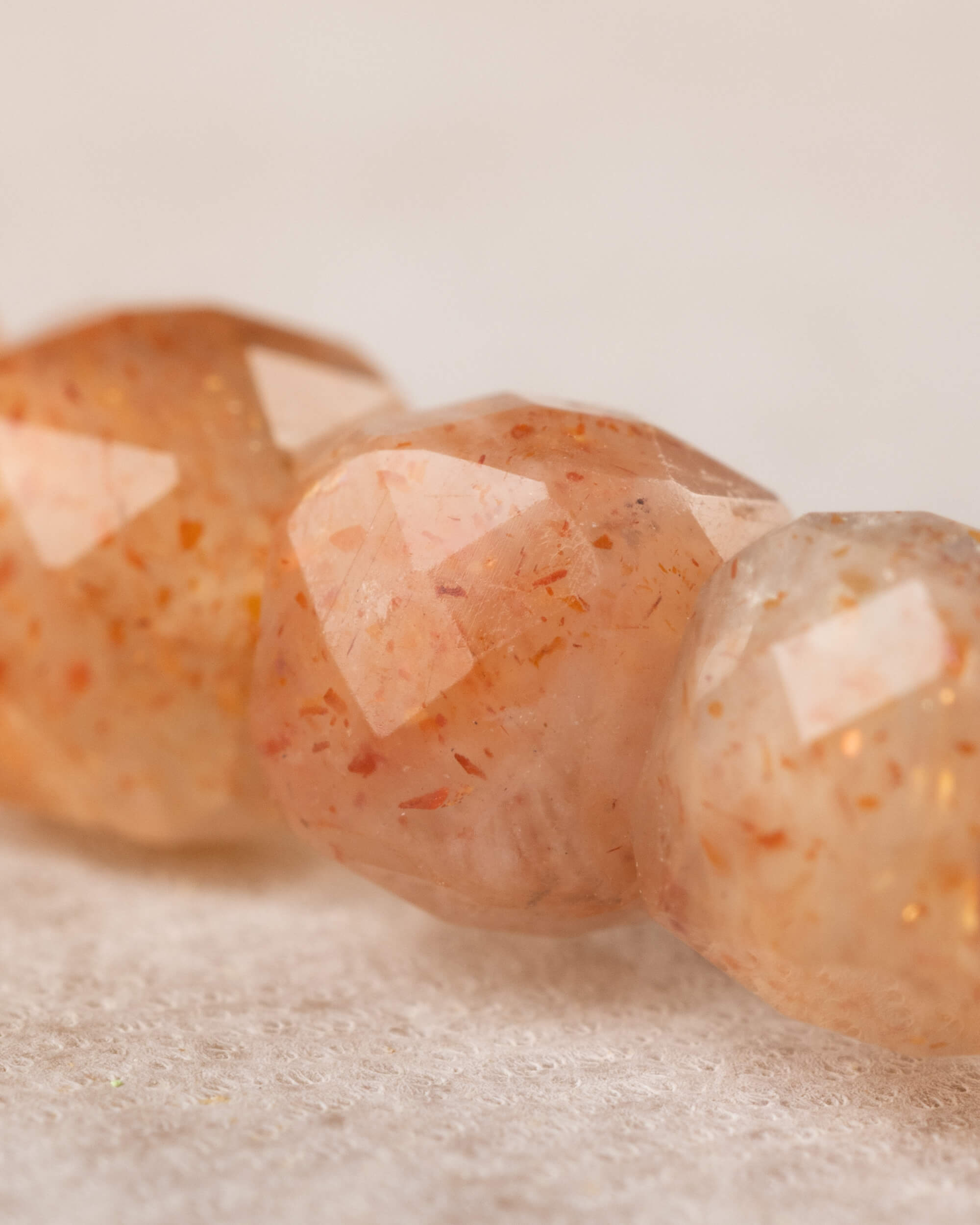 Acercamiento a las cuentas facetadas de Piedra Sol Naranja, tonos cálidos