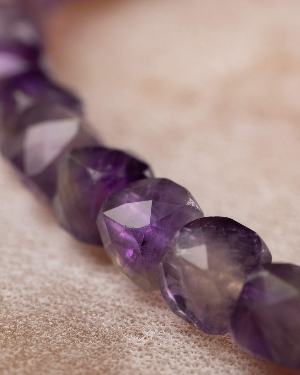 Detalle macro de las cuentas de Amatista en degradado de morado a violeta intenso