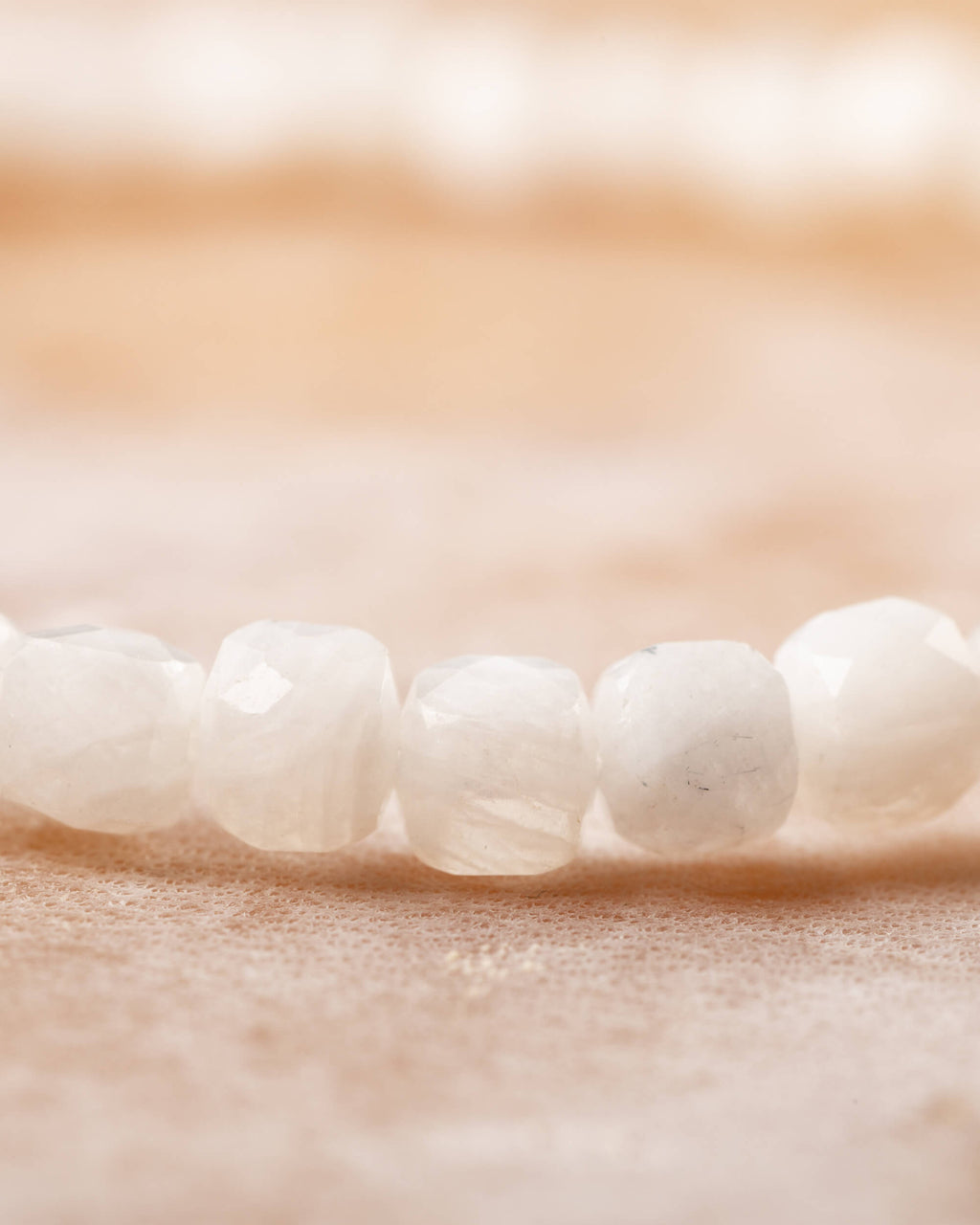 Detalle macro de las cuentas facetadas de Piedra Luna en tono blanco perlado