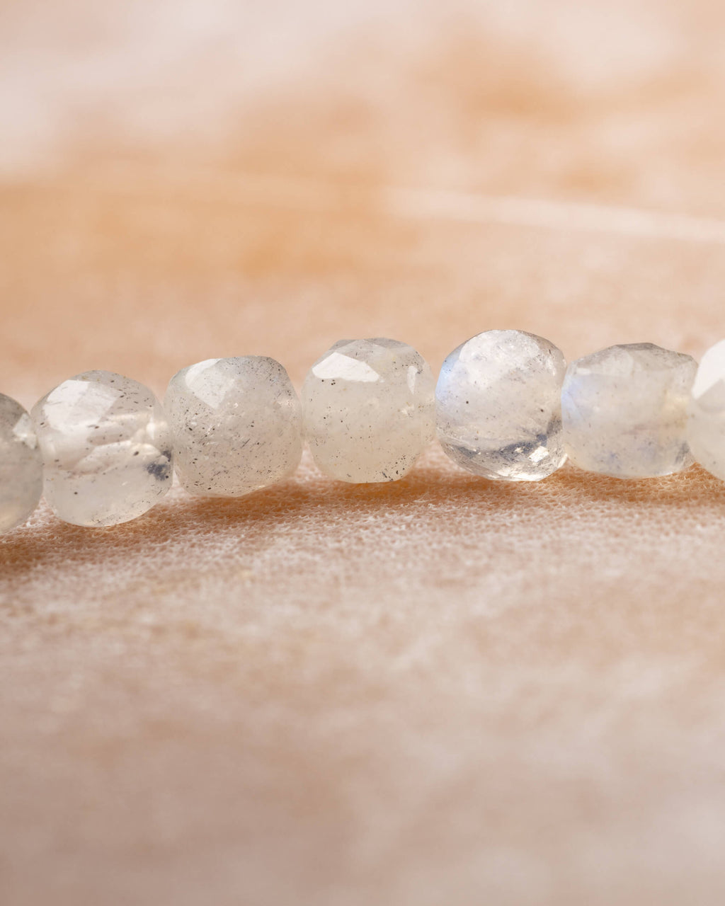 Detalle macro de las cuentas facetadas de Labradorita blanca en fila