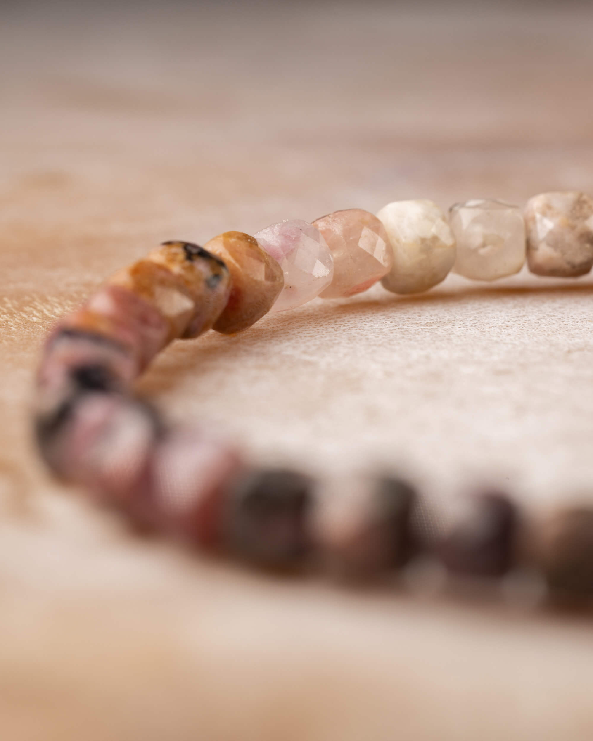 Pulsera de Rodonita en perspectiva, cuentas claras y rosadas al frente