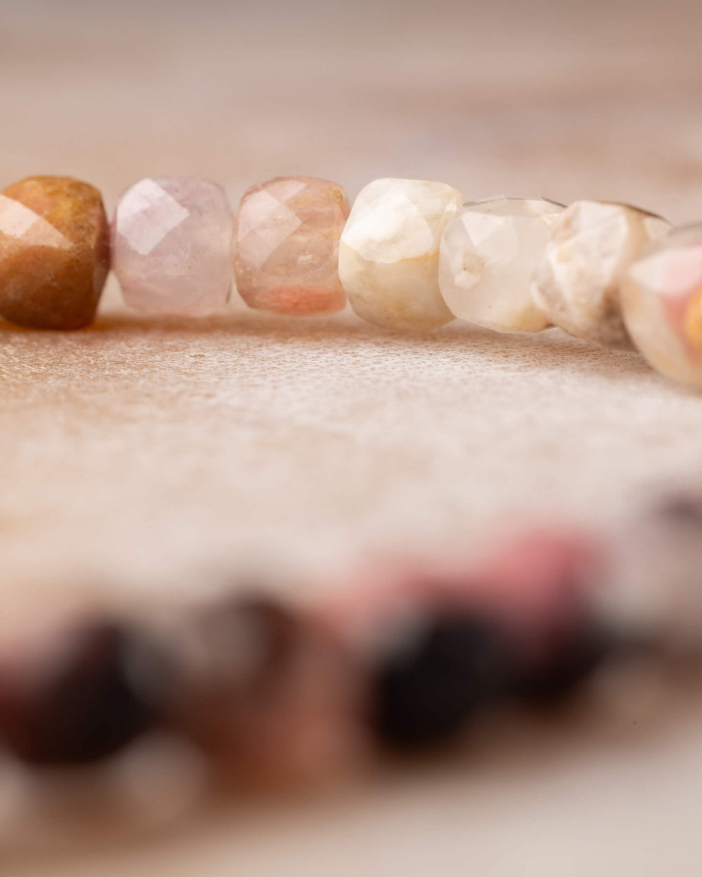 Pulsera de Rodonita en perspectiva, cuentas claras, lila y rosa al frente