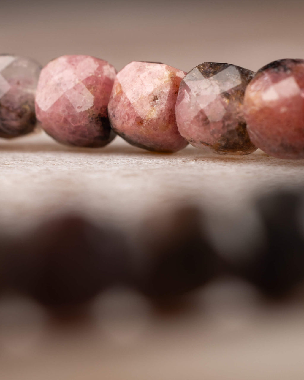 Pulsera de Rodonita en perspectiva, cuentas rosa intenso al frente