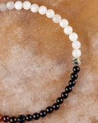 Detalle macro de las cuentas de Piedra Luna, Jaspe Dálmata y Turmalina Negra en la pulsera Unidad