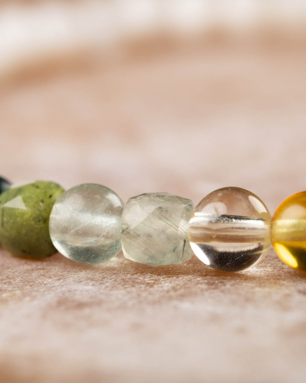 Detalle macro de las cuentas de Jade Verde, Prehnita, Citrino y Ámbar en la pulsera Unidad