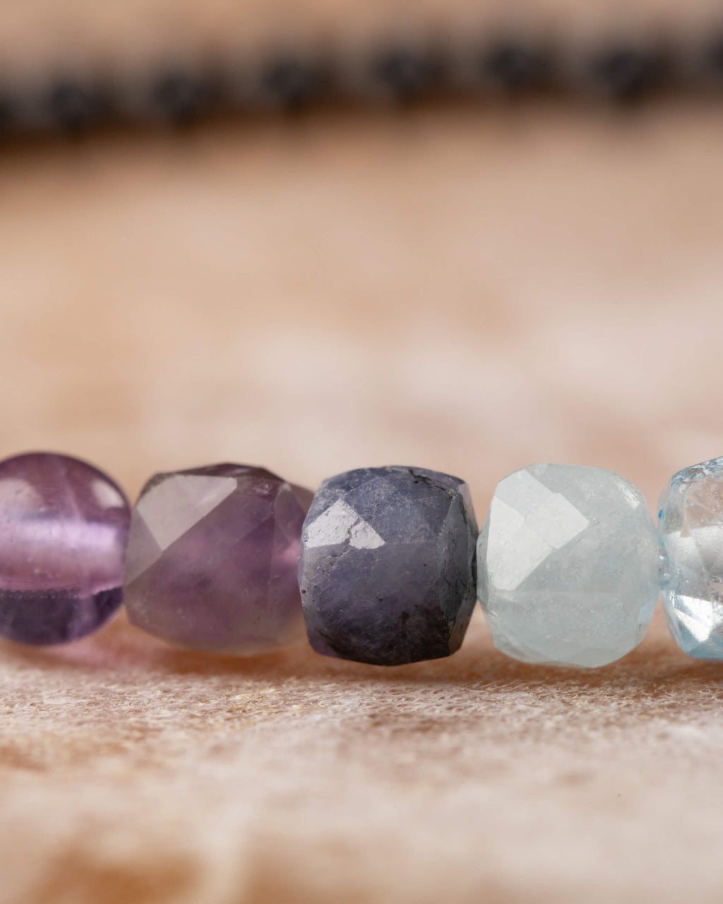 Detalle macro de las cuentas de Fluorita, Amatista y Tanzanita en la pulsera Unidad