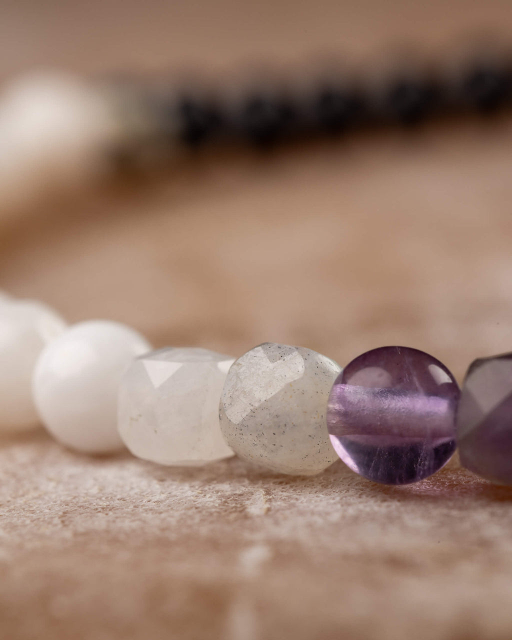 Detalle macro de las cuentas de Piedra Luna, Labradorita, Amatista y Fluorita en la pulsera Unidad