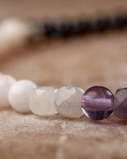Detalle macro de las cuentas de Piedra Luna, Labradorita, Amatista y Fluorita en la pulsera Unidad