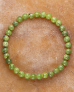 Pulsera de Jade Verde de 6 mm, pieza completa en forma circular sobre superficie de piedra