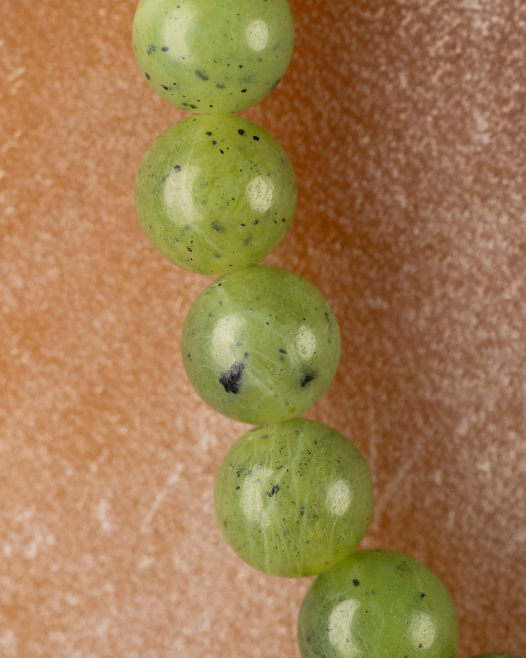 Detalle macro vertical de las cuentas redondas de Jade Verde