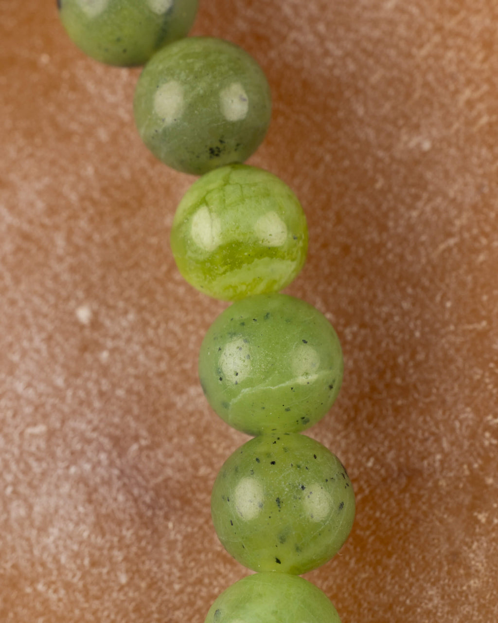 Detalle macro vertical de las cuentas de Jade Verde con brillo natural