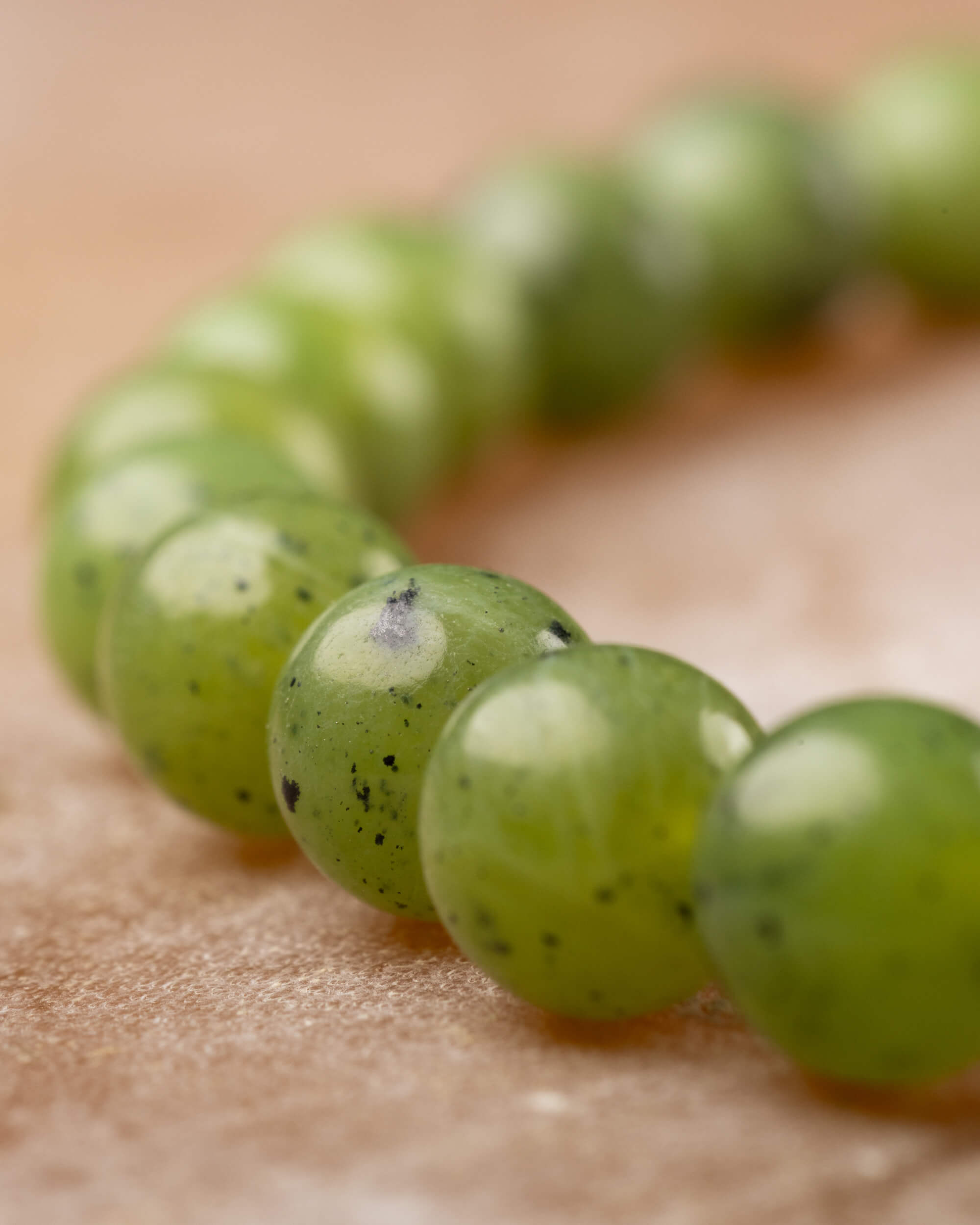 Pulsera de Jade Verde en perspectiva cercana sobre superficie de piedra clara