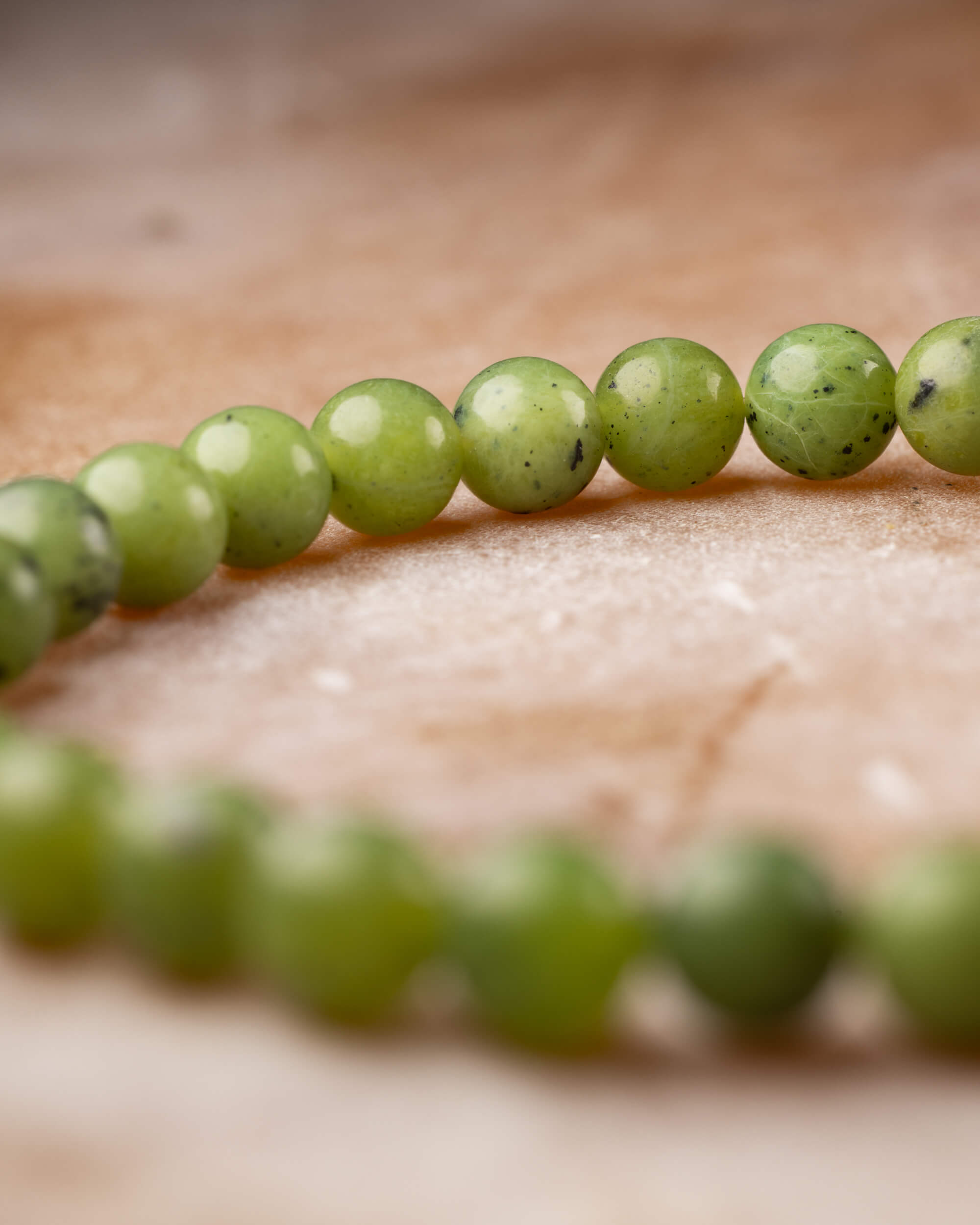 Pulsera de Jade Verde en perspectiva curva con cuentas en primer y segundo plano