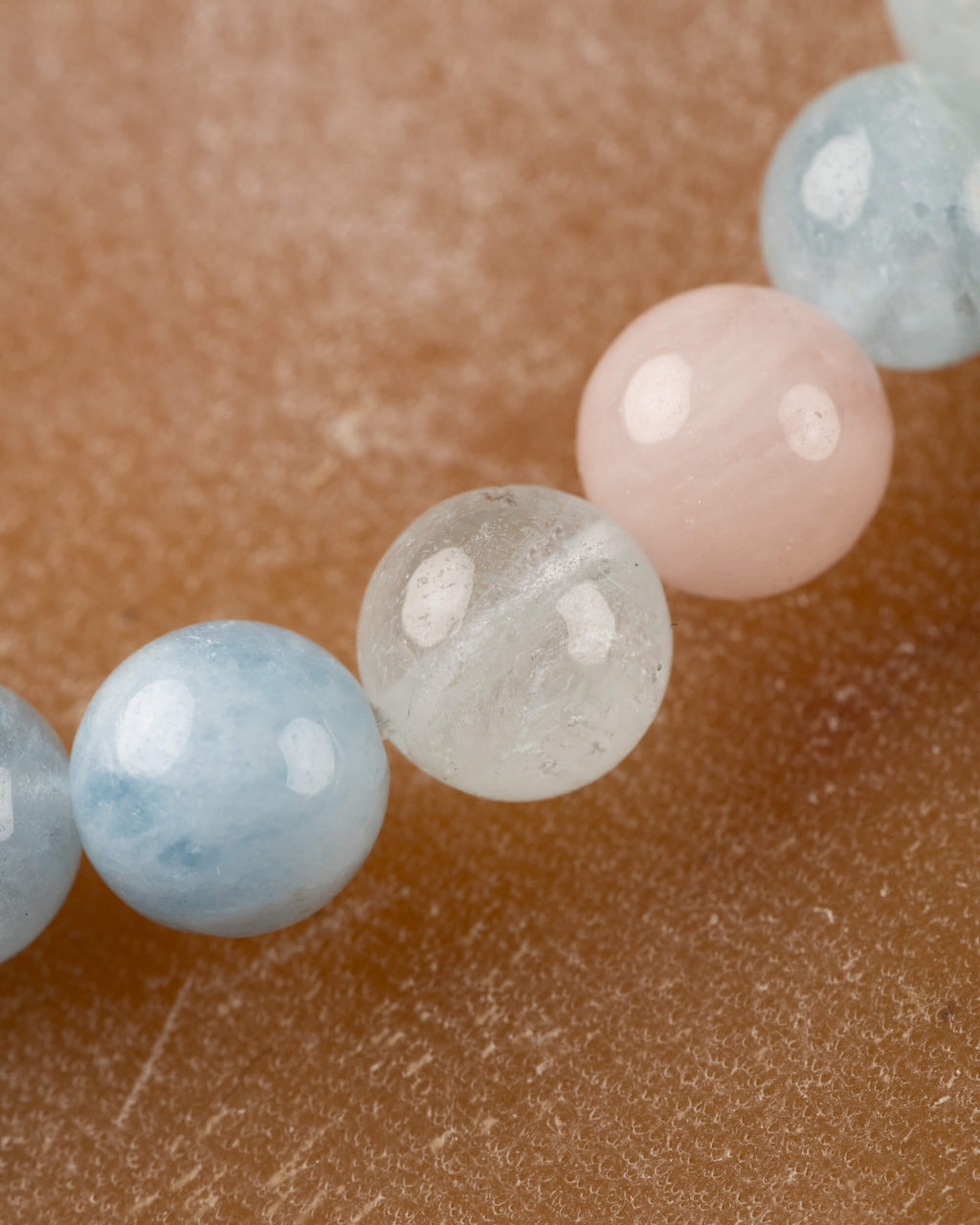 Cuentas de Berilos en primer plano, tonos azul aguamarina y rosa morganita
