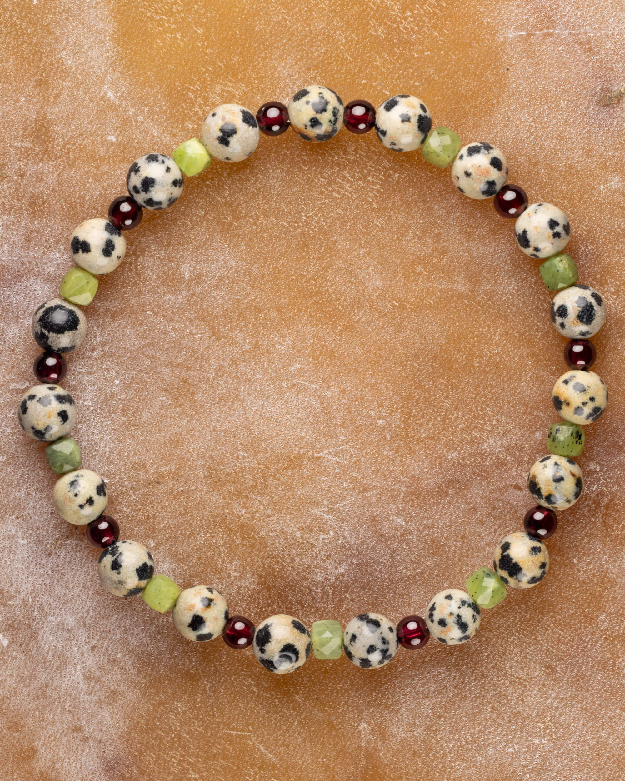 Pulsera Guerrero Alegre con Jade Verde, Jaspe Dálmata y Granate, pieza completa sobre superficie de mármol
