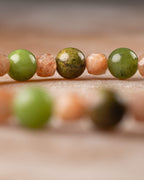 Cuentas de Jade Verde, Piedra Sol y Jaspe Unakita en fila, fondo desenfocado