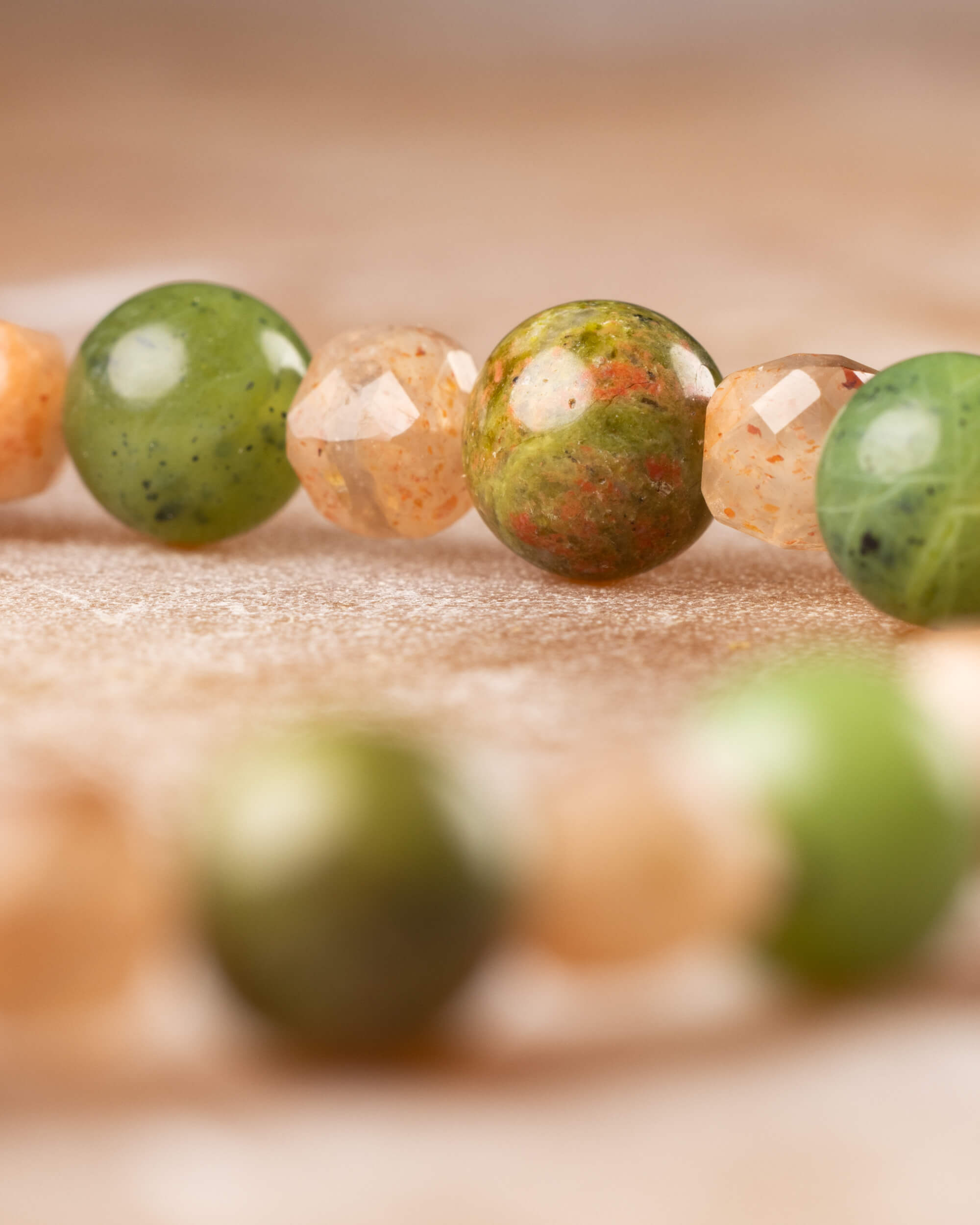 Detalle macro del Jade Verde y el Jaspe Unakita junto a las facetas de Piedra Sol