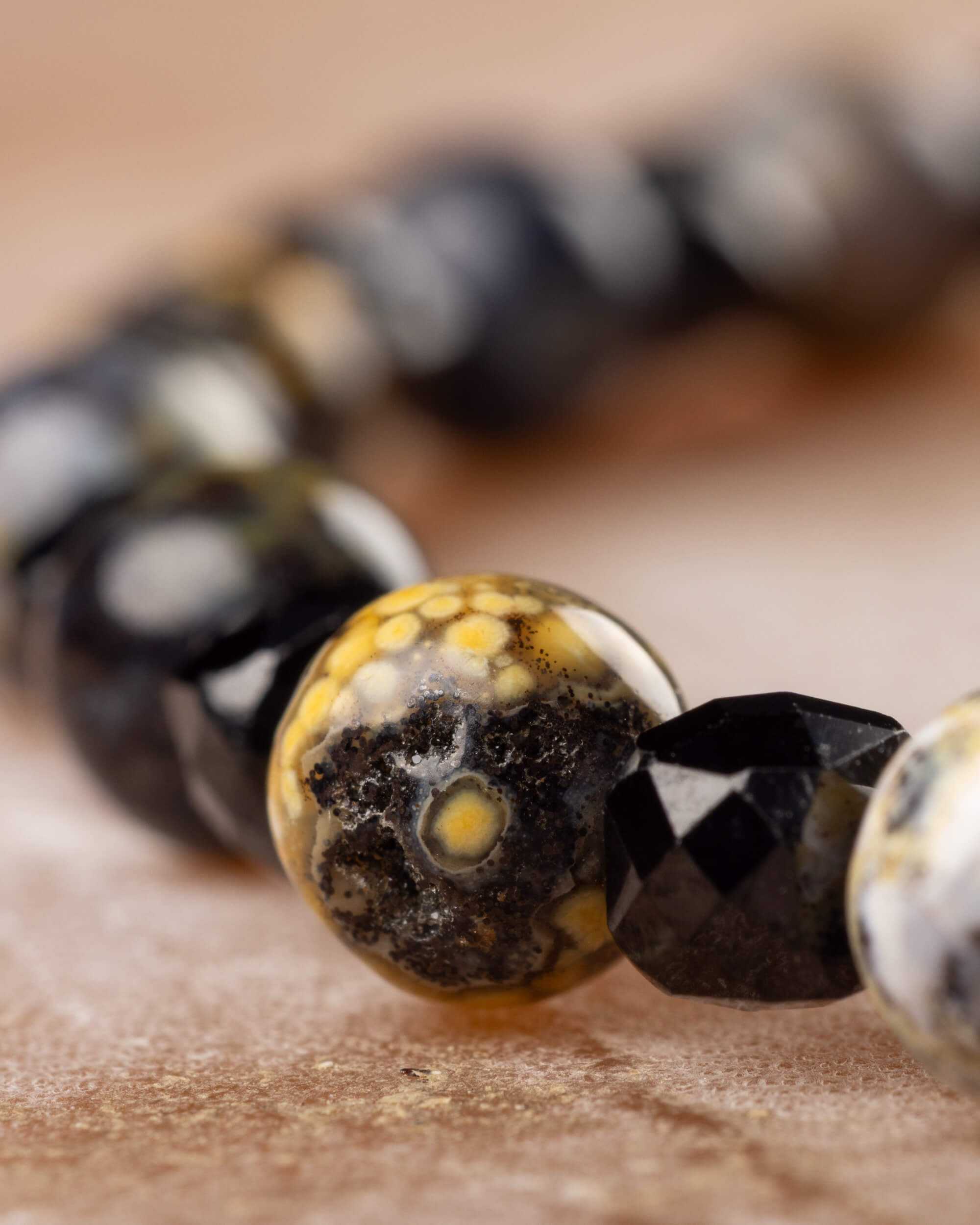 Detalle macro del Jaspe Oceánico moteado junto a las facetas de Espinela Negra