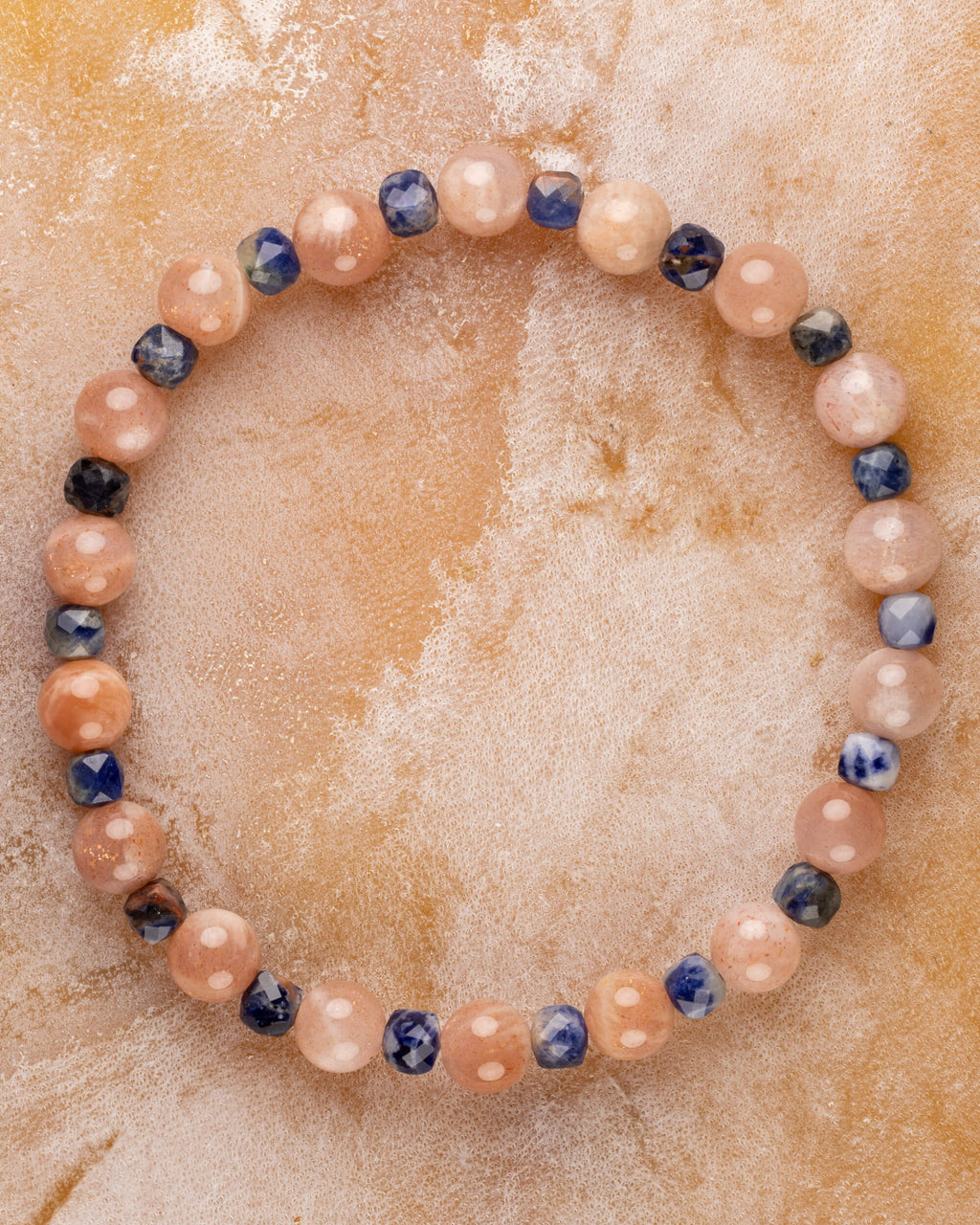 Pulsera de Piedra Sol y Sodalita, pieza completa en círculo sobre superficie clara