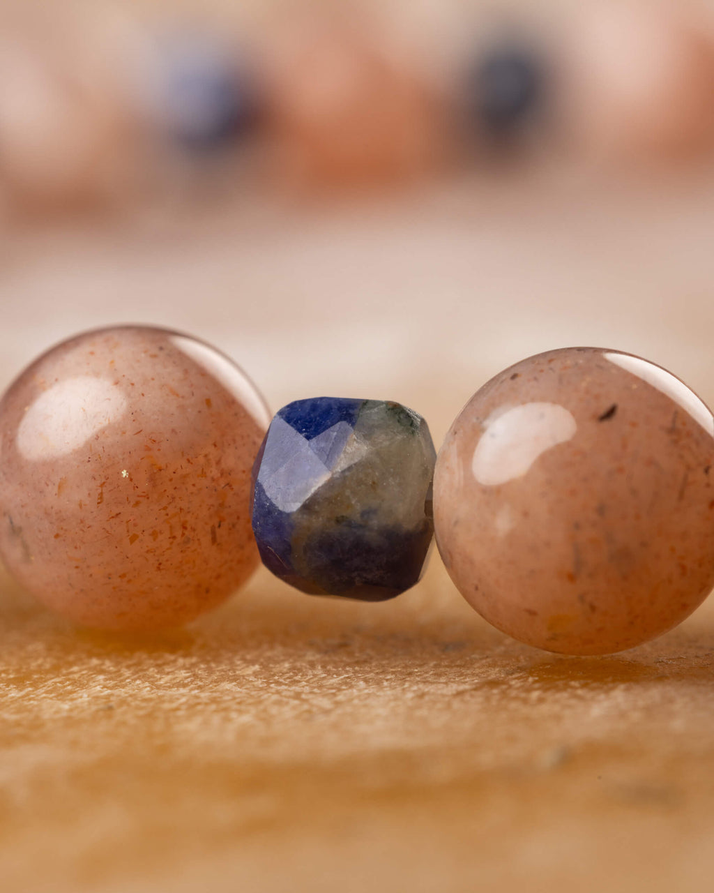 Detalle macro de una cuenta de Sodalita entre dos cuentas de Piedra Sol