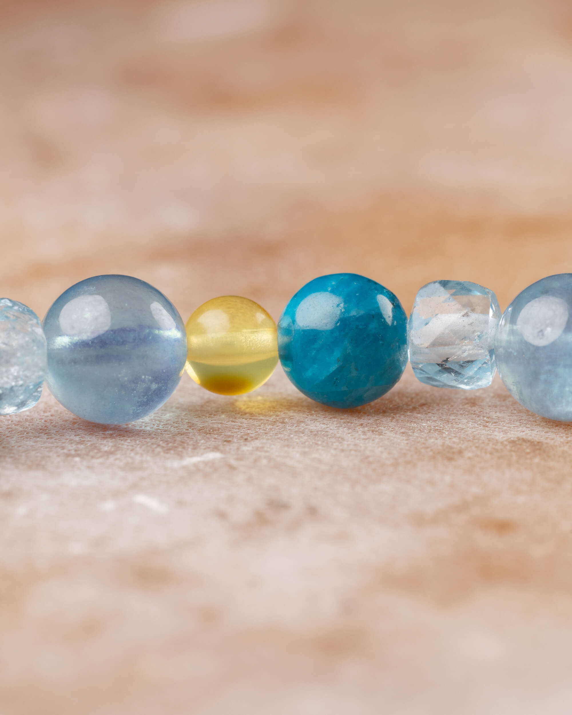 Detalle macro de las cuentas de Aguamarina, Ámbar y Apatita Azul con brillo